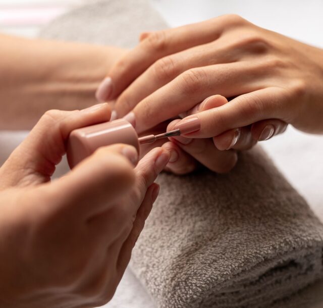 close-up-manicurist-applying-nail-polish